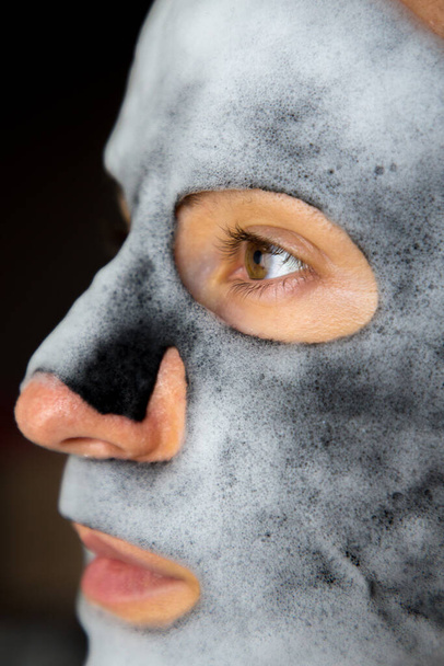 Isolated girl with cleansing mask on the face. - Foto, afbeelding