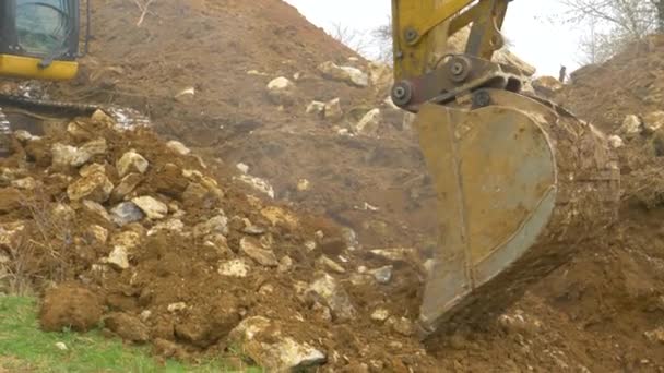 CERRAR: Nube de polvo blanco se eleva como excavadora cubo cava la suciedad y piedras - Metraje, vídeo