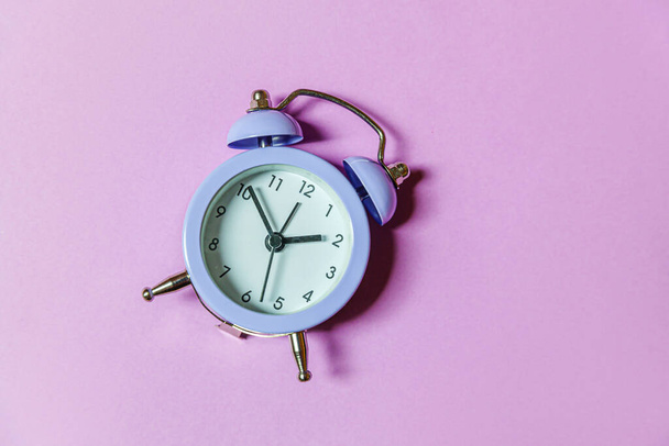 Simply minimal design ringing twin bell vintage classic alarm clock Isolated on purple violet background. Rest hours time of life good morning night wake up awake concept. Flat lay top view copy space - Foto, Imagen