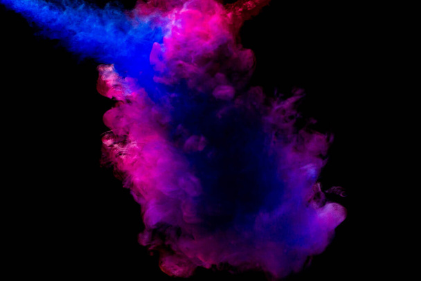 A cloud of pink and blue paint released into clear water. Isolate on a black background. - Foto, afbeelding