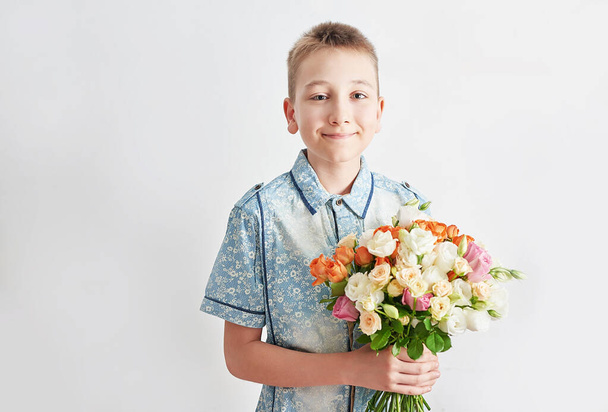 Child boy with bouquet of flowers. Mother's Day Greeting Card. Happy mothers day frame background. Spring card template. Happy Birthday or Valentine. Women's Day. Copy space. Child gives bouquet. - Foto, imagen