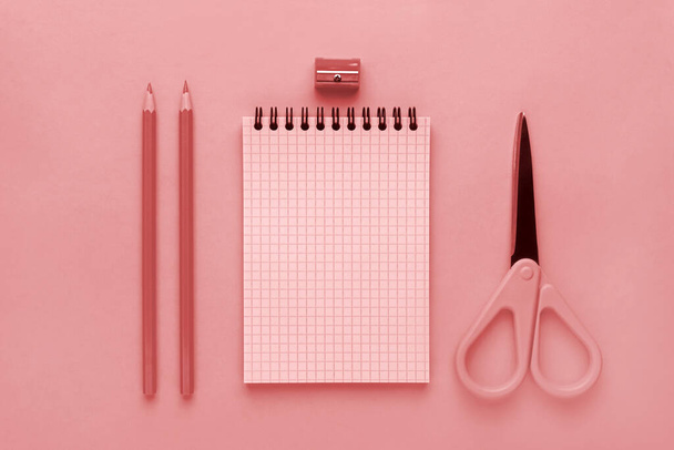 Notepad, pink pencil and pink scissors on a pink background - 写真・画像