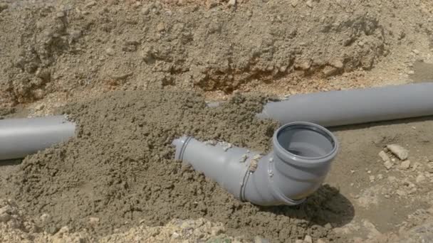 CLOSE UP: Fresh concrete covering plastic sewage tubing dries in the summer sun. - Footage, Video