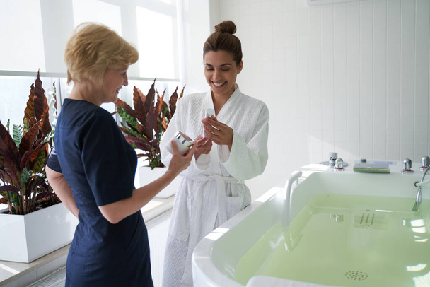 Contented lady choosing beauty products in spa salon - Zdjęcie, obraz