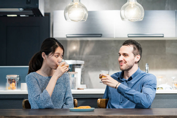 young man and woman toasting with glass of beer at home - Photo, Image