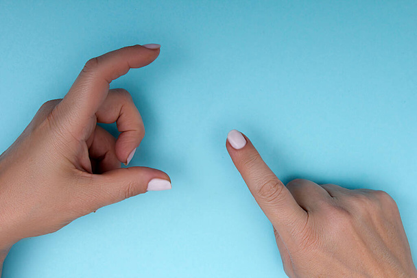 Female hands gestures on a blue background - Foto, afbeelding