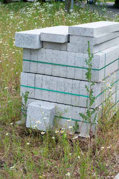szürke betontömbök műanyag szalaggal megkötözve a réten - Fotó, kép