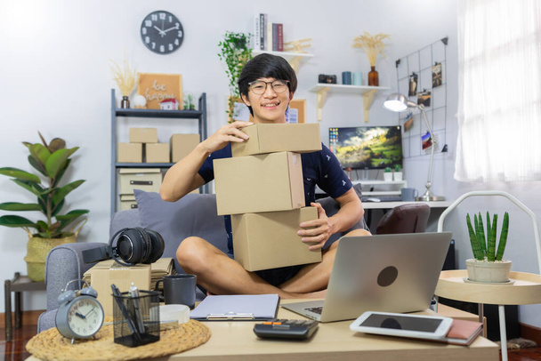Азиатский мужчина владелец бизнеса или продажи merchance онлайн и подготовить продукт упаковки картонная коробка для отправки заказа отгрузки клиенту на дом, покупки в Интернете, владелец бизнеса, концепция доставки - Фото, изображение