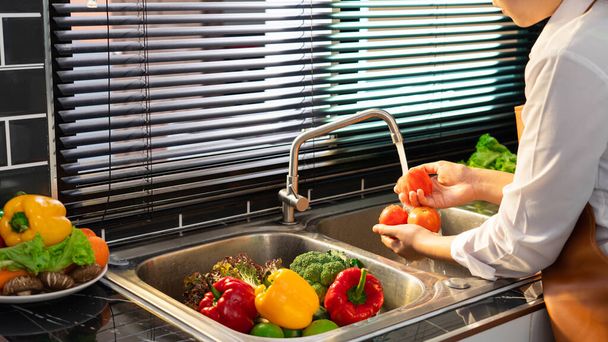Mulher mãos lavar Legumes para Preparação de salada vegan na bancada perto de afundar em uma cozinha moderna, Conceito de comida saudável caseiro - Foto, Imagem