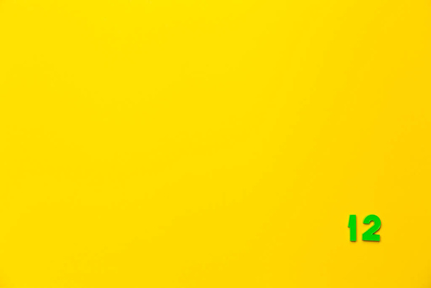 A zöld műanyag játék száma tizenkettes található a jobb alsó sarokban sárga alapon. - Fotó, kép