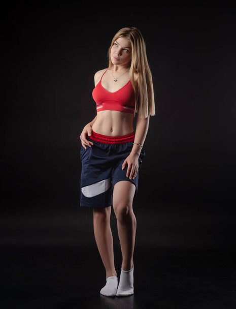 спортивная девушка в боксёрских шортах на черном фоне - Фото, изображение