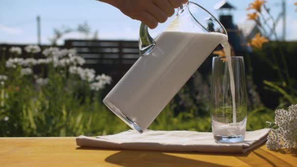 Рука наливает молоко в стакан - Кадры, видео