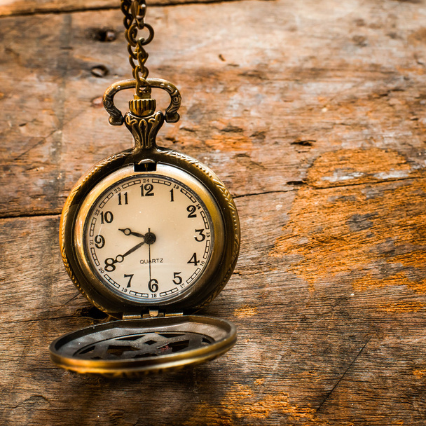 Vintage pocket watch on chain on wooden background with still li - Photo, Image