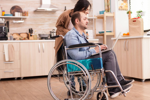 Homem com deficiência em cadeira de rodas usando laptop - Foto, Imagem