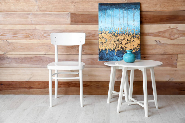 Καρέκλα με τραπέζι κοντά σε ξύλινο τοίχο στο δωμάτιο - Φωτογραφία, εικόνα