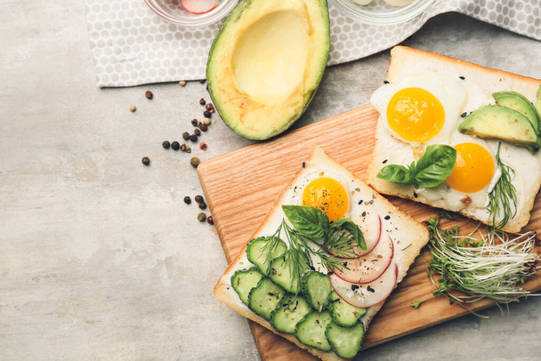 Board with tasty avocado sandwiches on table - Foto, imagen