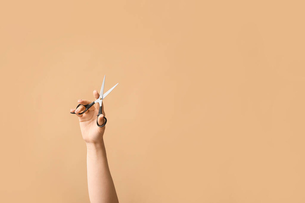 Kobieta ręka nożyczki fryzjerskie na tle koloru - Zdjęcie, obraz