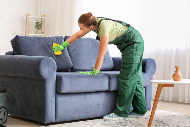 Empleado de la tintorería quitar la suciedad del sofá en casa - Foto, Imagen