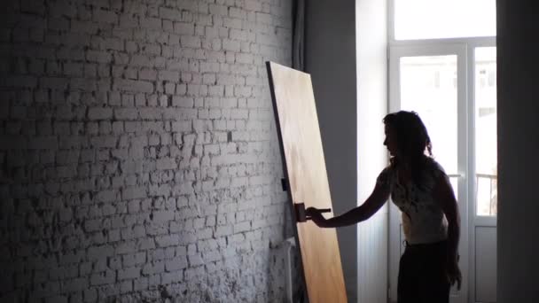 Dívka malíř klidně maluje obraz abstraktní technikou, pomalu ležel na olejomalba na plátně s širokými tahy pomocí štětce. Dívka kombinující různé techniky v kreativitě. - Záběry, video