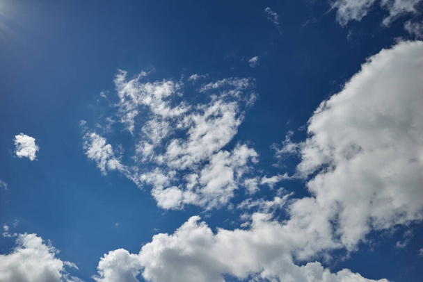 Promienie słońca rozświetliły błękitne niebo pokryte chmurami - Zdjęcie, obraz