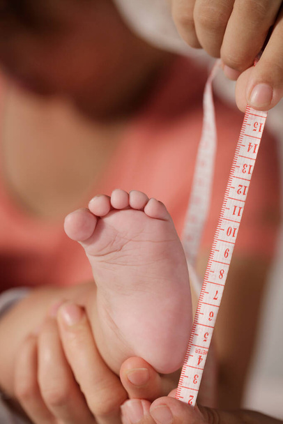 Mother measuring baby foot - Foto, Imagen
