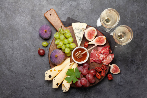 Placa antipasto com presunto, queijo, figos e uvas. Placa de aperitivo e vinho branco. Top vista plana leigos com espaço de cópia - Foto, Imagem