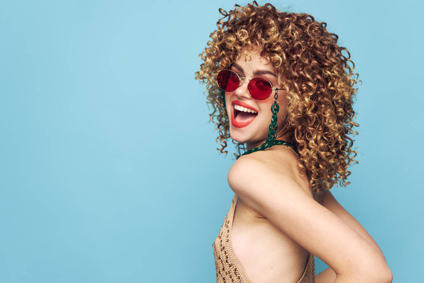 Sweet lady disco on an isolated blue background, red sunglasses  - 写真・画像