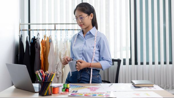 Fashion designers are working in workshops with laptops and design drawings on their desks, Creating a new collection of clothes, Creation of the work of the designer. - Фото, изображение