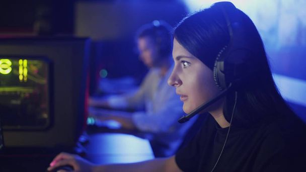 Yakın plan bir kadın bir bilgisayar kulübünün koridorunda oturuyor ve online bir oyun oynuyor. Modern bilgisayar kulübü. - Fotoğraf, Görsel