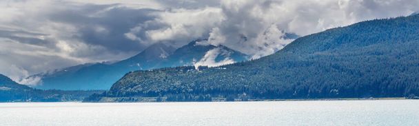 Сцена Сережи у горного озера в Канаде с обвалом скал в спокойной воде. - Фото, изображение