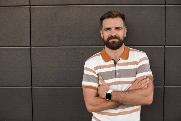 Portrait of a casual man with beard outdoor near black background - Photo, image