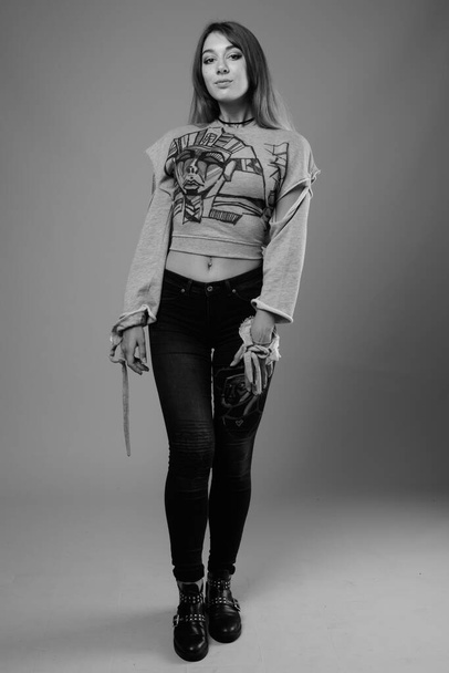 Estúdio tiro de jovem bela mulher rebelde contra fundo cinza em preto e branco - Foto, Imagem