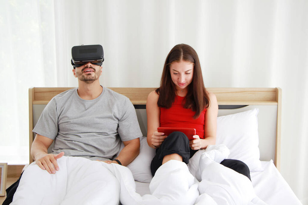 Lachen Kaukasisch echtpaar liefde ontspannen met Virtual Reality glazen doos op tablet in social media online spel met partner in de slaapkamer. Technologie en levensstijl van het gehuwde gezin op vakantie Concept. - Foto, afbeelding