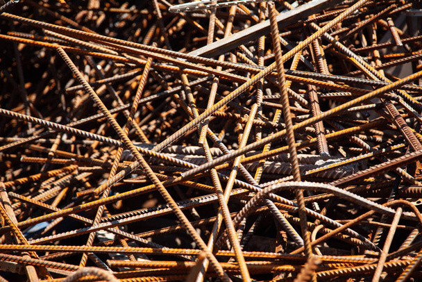 Σκουριασμένα χαλύβδινα αποκόμματα. Στοίβα από σκουριασμένες ράβδους ή ράβδους σιδήρου - Φωτογραφία, εικόνα