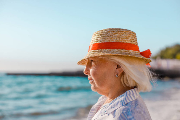 žena v slaměném klobouku dívá na moře - Fotografie, Obrázek