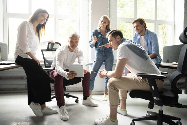 Skupina mladých moderních lidí v elegantním neformálním oblečení má brainstorm setkání v kreativní kanceláři - Fotografie, Obrázek