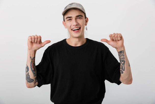 Portrait closeup of laughing man wearing black clothes looking at camera and pointing fingers at himself over white background - Foto, immagini
