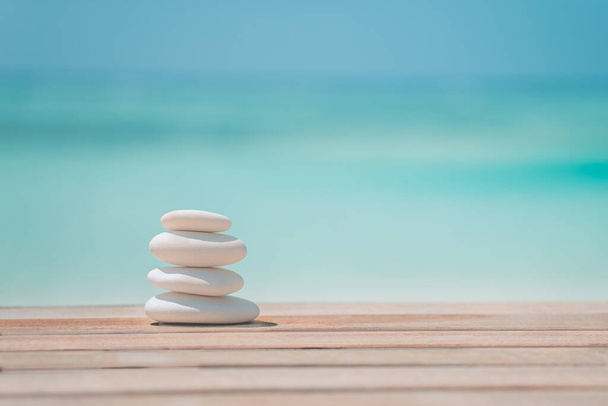Zen stones on tropical beach for perfect meditation. Stones pyramid on soft sandy beach symbolizing stability, zen, relaxation, harmony, balance, inspirational, sea, peace. Shallow depth of field. - Photo, Image