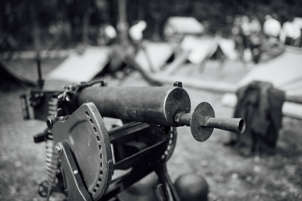 Těžký kulomet z I. světové války s vojenským táborem v pozadí - Fotografie, Obrázek