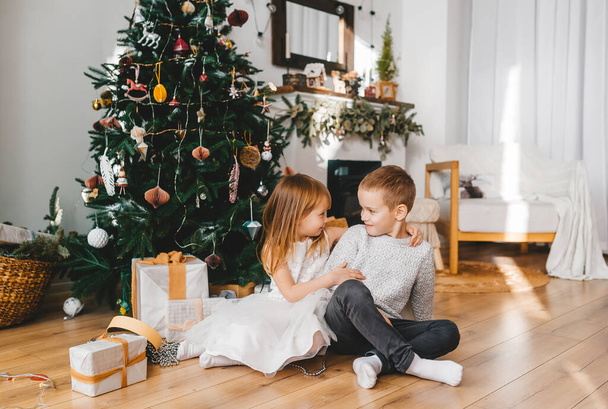 La petite sœur offre un cadeau à son frère. Joyeux Noël et Nouvel An Concept. - Photo, image
