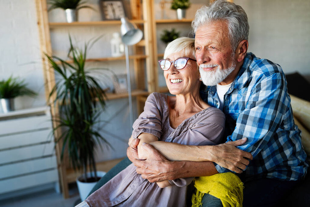 Happy smiling senior couple embracing together and enjoying retirement at home - Foto, imagen