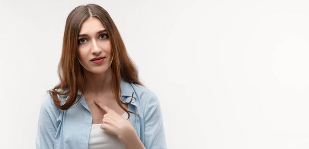 Photo of of indignant brunette female with long straight hair, points at herself with for finger, opens mouth in surprisement, has dissatisfied expression, strartled by offensive words. - Valokuva, kuva
