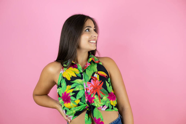 Young beautiful woman over isolated pink background smiling and looking side - 写真・画像