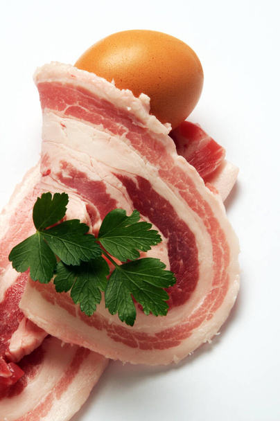 Fatias de bacon com um ovo
 - Foto, Imagem