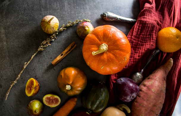 Φρέσκα λαχανικά στο γκρι τραπέζι. Top view φωτογραφία του βουτυρόκαρπου, κολοκύθα στολίδι, κολοκύθα, χρυσό ψήγμα, καρότο, σύκα, γλυκοπατάτα, κρεμμύδι, πορτοκάλια και μαϊντανό. Φθινοπωρινή συγκομιδή Έννοια υγιεινής διατροφής. - Φωτογραφία, εικόνα