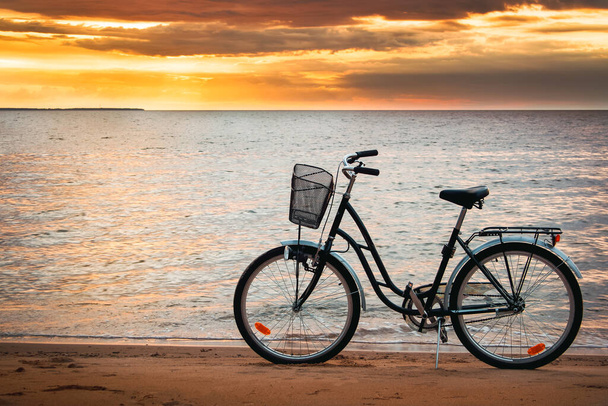 Lonely bike standing at sunset at seaside - Foto, immagini