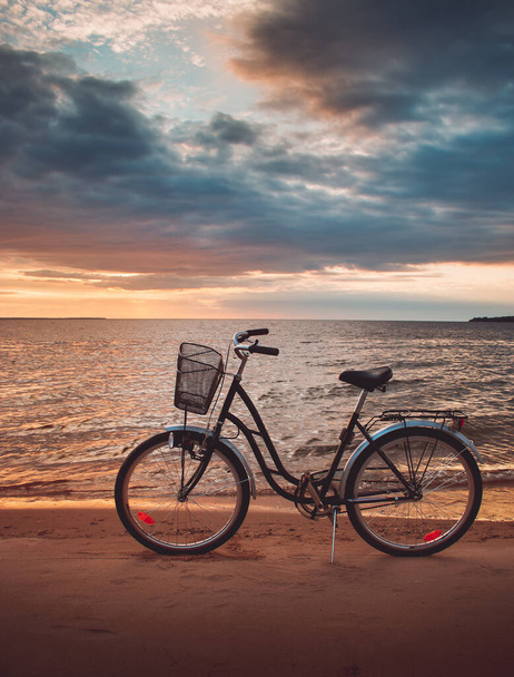 Lonely bike standing at sunset at seaside - Foto, Bild