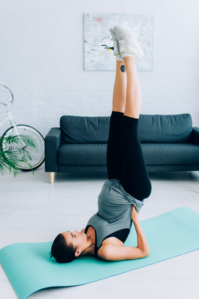 Pregnant woman training on fitness mat in living room  - 写真・画像