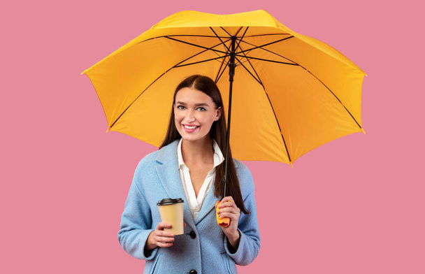 Portrait of beautiful young girl holding yellow umbrella - Fotografie, Obrázek