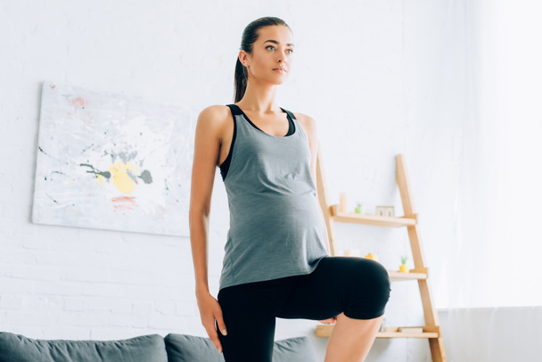 Pregnant woman working out in living room  - Fotoğraf, Görsel